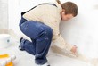 Man painting wall with small roller