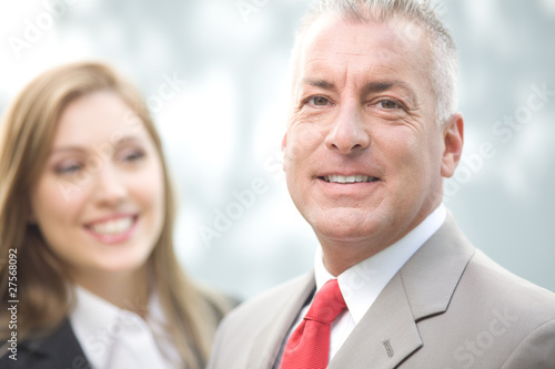 Photo: Businessman with assistant in the background Businessman with assistant in the background