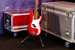 A red bass guitar and two cases on a stage