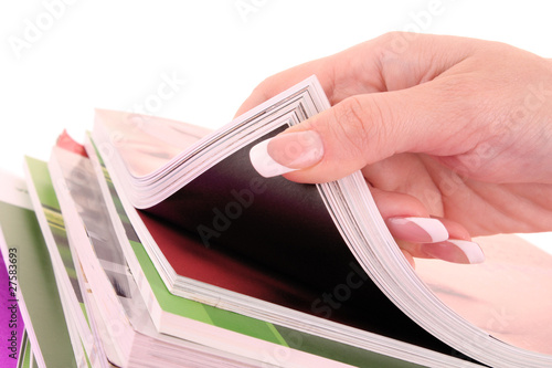 Photo: hand browsing through stack of magazines hand browsing through stack of magazines