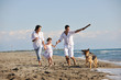 happy family playing with dog on beach happy family playing with dog on beach
