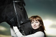 Beautiful young woman with a black horse