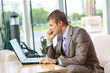 Businessman sitting at table in office hall, talking Businessman sitting at table in office hall, talking
