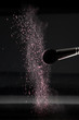 detail of a blush brush with pink loose powder blush