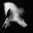 detail of a powder brush with white loose powder