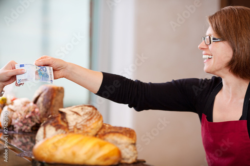 Foto: verkäuferin mit 20 Euro in der Bäckerei verkäuferin mit 20 Euro in der Bäckerei
