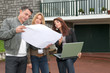 Couple and architect looking at plan of a house
