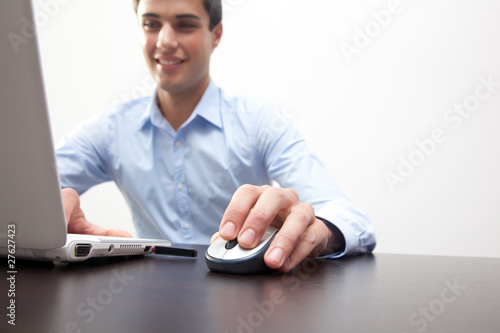 Foto: Successful young business man typing on the laptop Successful young business man typing on the laptop