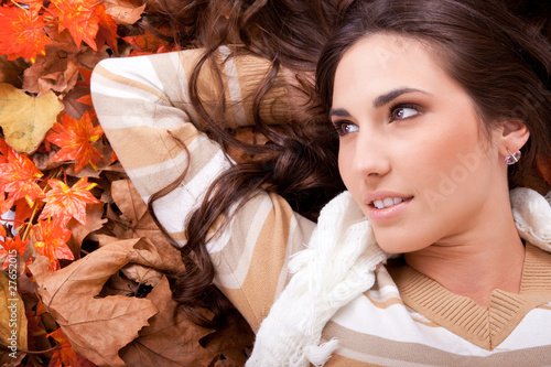 Photo: brunette woman lying on autumn leaves brunette woman lying on autumn leaves