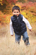Photo: Portrait of happy toddler playing outdoors in the fall Portrait of happy toddler playing outdoors in the fall