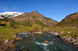 The mountain river in gorge and snow-white mountain peaks The mountain river in gorge and snow-white mountain peaks