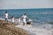 happy family playing with dog on beach happy family playing with dog on beach