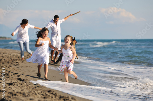 Photo : happy family playing with dog on beach happy family playing with dog on beach