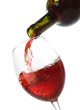Pouring red wine into a glass isolated on white Pouring red wine into a glass isolated on white