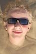 Boy relaxing on summer beach in sunglasses