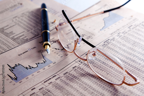 Foto: fondo de negocios con graficos,gafas y pluma fondo de negocios con graficos,gafas y pluma