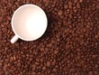 Coffee cup standing in coffee beans