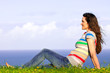 A beautiful young woman relaxing in the grass by the ocean
