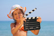 girl standing on beach and holding clapboard. focus on girl eyes