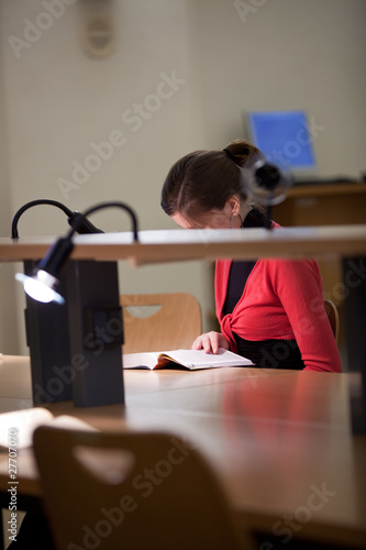 Foto: pretty female college student in a college library (shallow DOF; pretty female college student in a college library (shallow DOF;