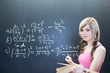 pretty young college student writing on the chalkboard/blackboar pretty young college student writing on the chalkboard/blackboar