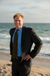 Attractive  business man on the beach at sunset