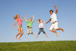 Young couple with children jump in a field