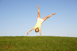Young woman cartwheels in field