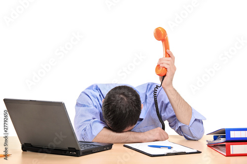 Photo: Exhausted businessman holding a telephone tube Exhausted businessman holding a telephone tube