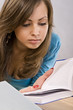 beautiful girl thoughtfully reading a book, surrounded by books