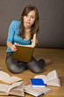 beautiful girl thoughtfully reading a book, surrounded by books