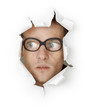 Funny man in an old-fashioned glasses looking out of hole