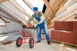 Builder roofer and wheel barrow with clay tile
