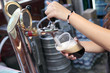 Pouring dark beer to plastic glass from beer tap