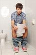 Young handsome man sitting on toilet Young handsome man sitting on toilet