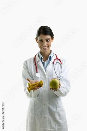 Photo: Doctor holding apple and hand weights Doctor holding apple and hand weights