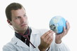 Doctor holding stethoscope to globe
