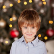 glücklicher junge vor dem weihnachtsbaum