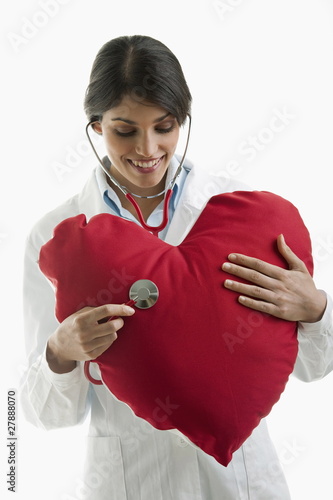Photo: Doctor with stethoscope on heart pillow Doctor with stethoscope on heart pillow