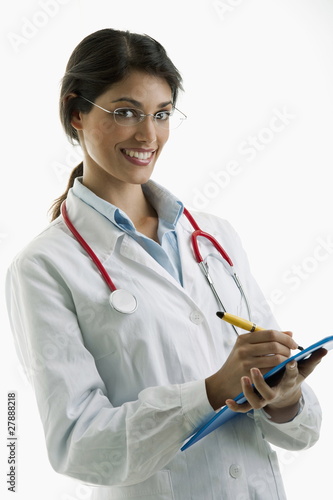 Foto: Doctor wearing stethoscope and writing on chart Doctor wearing stethoscope and writing on chart