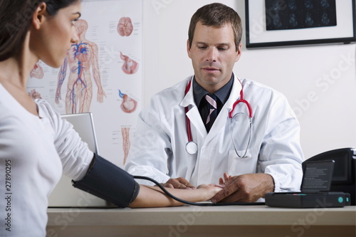 Photo: Doctor taking patient's blood pressure Doctor taking patient's blood pressure