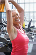Active woman exercising with dumbbells in health club