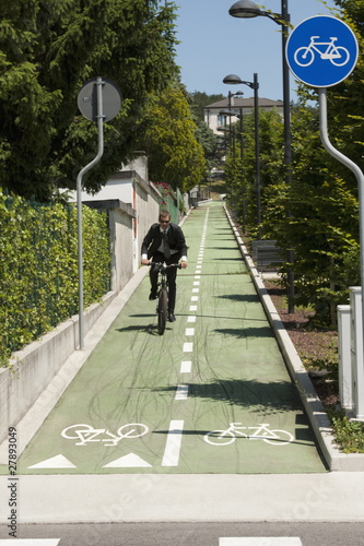 Photo: Businessman in suit riding bicycle to work Businessman in suit riding bicycle to work