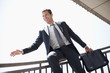 Businessman in suit sliding down bannister