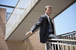 Businessman in suit sliding down bannister