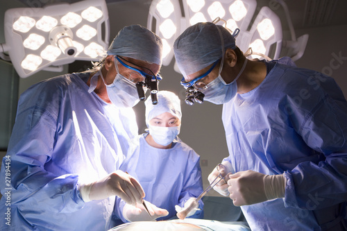Photo: Concentrating surgeons performing operation in operating room Concentrating surgeons performing operation in operating room