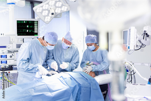 Photo: Concentrating surgeons performing operation in operating room Concentrating surgeons performing operation in operating room