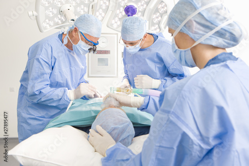 Photo: Concentrating surgeons performing operation in operating room Concentrating surgeons performing operation in operating room