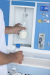 Closeup of man's hands filling milk bottle at cooler