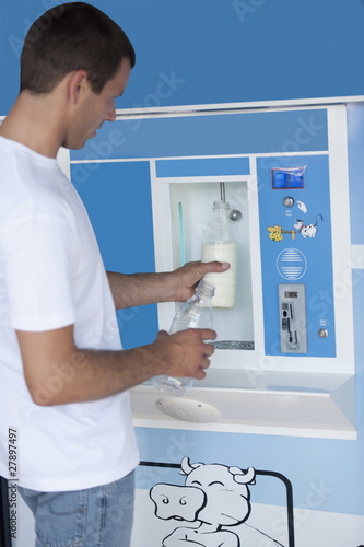 Photo: Man filling milk bottle at cooler Man filling milk bottle at cooler